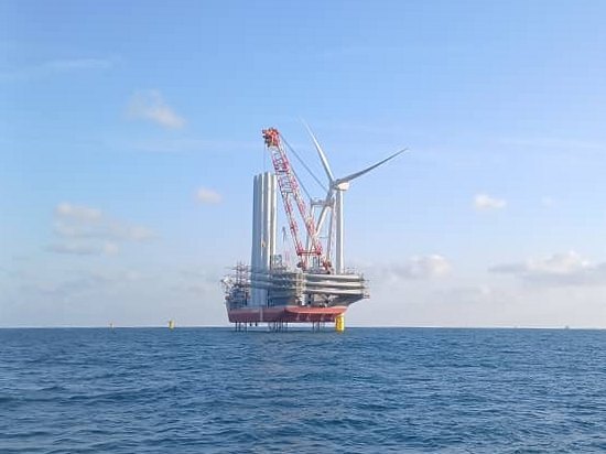 A jack-up installation vessel setting a wind turbine at sea