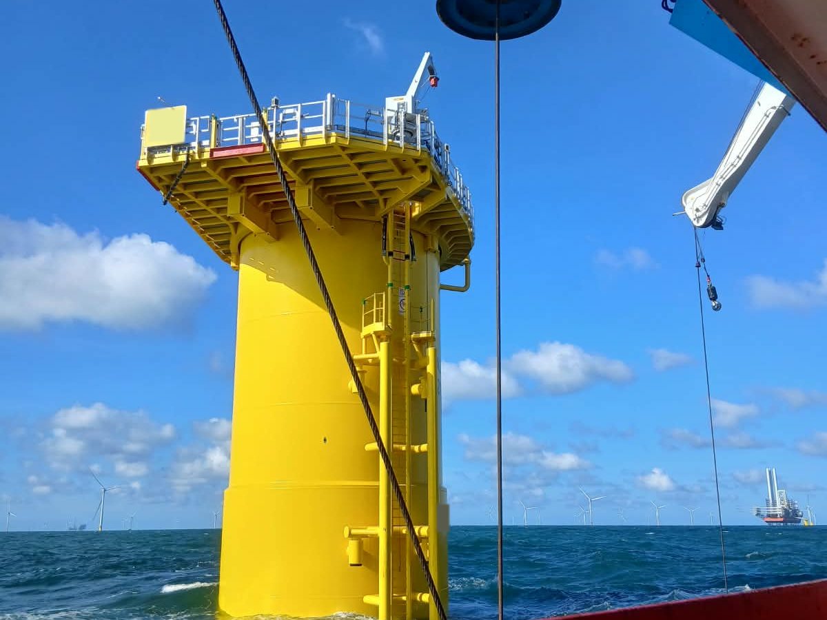 A wind turbine foundation and its transition piece, seen from the survey vessel
